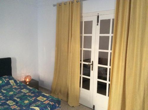 a bedroom with a bed and a door with curtains at Mouhib Sidi Bou Saïd House in Sidi Bou Saïd