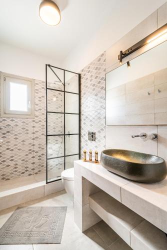 a bathroom with a sink and a tub at Caldera Stories private suites in Megalokhori