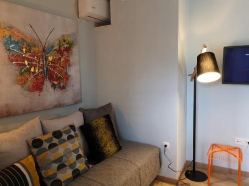 un soggiorno con divano e un dipinto di una farfalla di Orange Cube Apartment - Self check in - Free parking a Fiume (Rijeka)