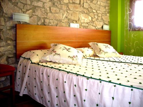 a bed with a wooden headboard in a room at Mircla in Rocafort de Queralt