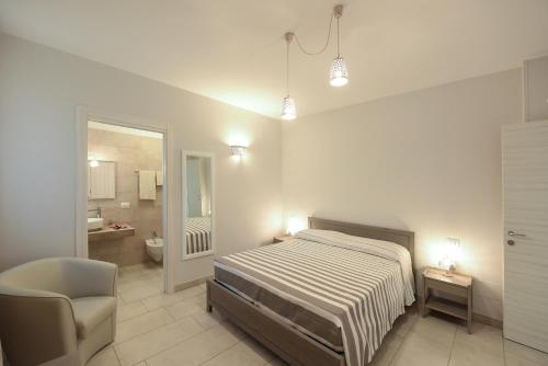 sypialnia z łóżkiem i krzesłem oraz łazienka w obiekcie Terra Mater - Exclusive Cottage - w mieście Ostuni