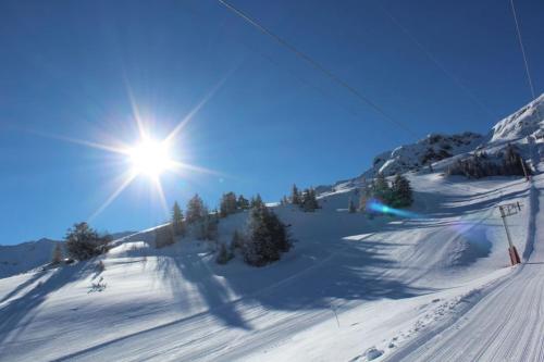 a sun is shining on a snow covered ski slope at VILLA VACANCES NEUVE in Bompas