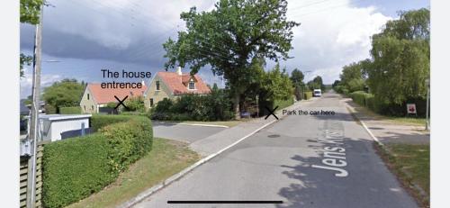 an empty street with a sign that reads the house exchange and part of the house at Cosy little guesthouse near beach & public transport in Greve Strand