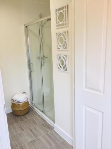 a shower with a glass door in a bathroom at Stansted Coach House - Apartment Hotel in Elsenham