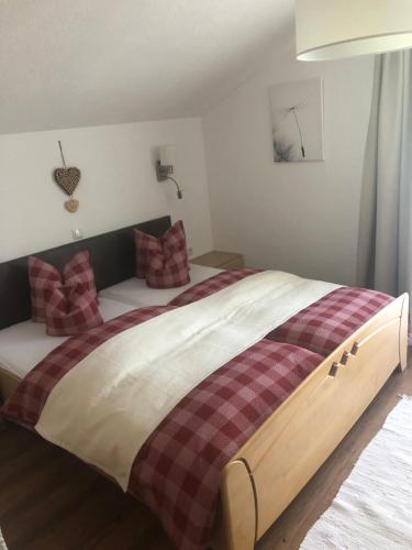 a bedroom with a large bed with plaid pillows at Haus am Wald in Neustift im Stubaital