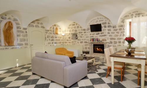a living room with a couch and a table and a fireplace at Apartments Zebra in Tivat