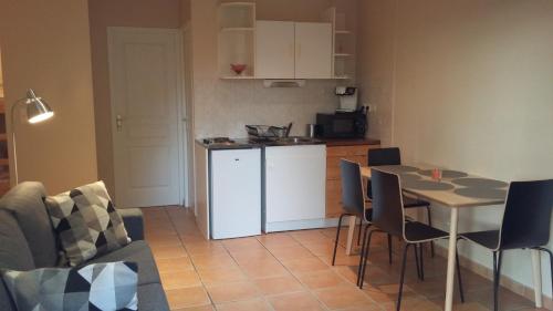 a kitchen with a table and a white refrigerator at Appartement dans propriété calme en pleine nature in Charbonnières-les-Bains