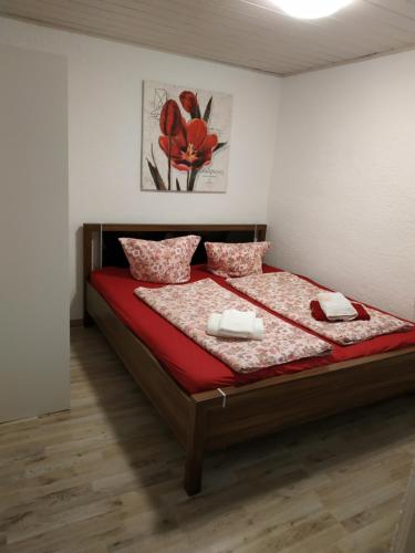sypialnia z dużym łóżkiem z czerwoną pościelą i poduszkami w obiekcie WMR w mieście Ellhofen