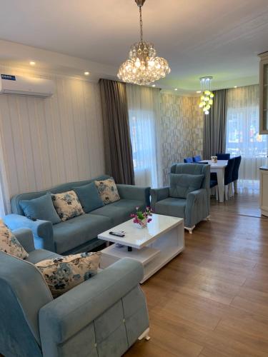 a living room with blue couches and a table at Квартира in Tbilisi City