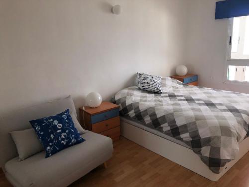 ein Schlafzimmer mit einem Bett und einem Sofa in der Unterkunft Calle del Sol Bajamar Apartment in La Laguna