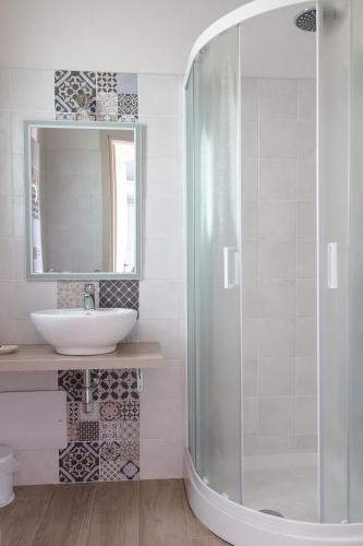 a bathroom with a glass shower and a sink at Mediterraneo in San Teodoro