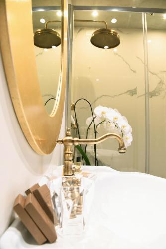 a bathroom sink with a gold faucet and a mirror at Ilsanleonardo in Bergamo