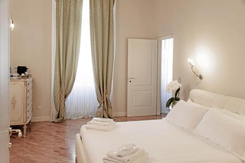 a bedroom with a white bed and a window at Ilsanleonardo in Bergamo