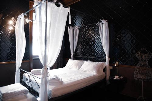 Schlafzimmer mit Himmelbett und weißen Vorhängen in der Unterkunft Ilsanleonardo in Bergamo