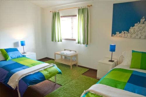 - une chambre avec 2 lits et une fenêtre dans l'établissement Casa Do Castelo, à Guimarães