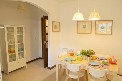 a dining room with a table and white chairs at Casa Do Castelo in Guimarães