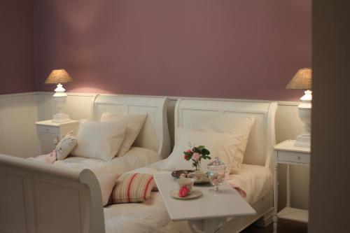 a bedroom with a white bed with a table at Rose Residence in Dobroszyce
