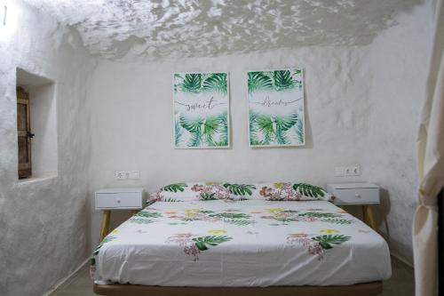 a bedroom with a bed and two pictures on the wall at Casa Rural Las Colmenas in Alcalá del Júcar