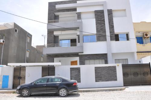 a black car parked in front of a building at Apartment zone touristique 80 m beach free wifi in Mahdia