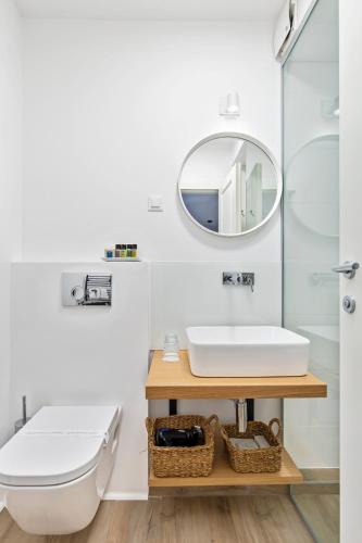 a bathroom with a toilet and a sink and a mirror at Blubini Heritage House in Rovinj