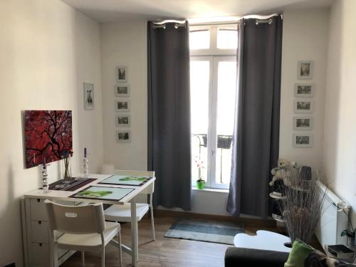 ein Esszimmer mit einem Tisch und einem Fenster in der Unterkunft Studio *** Centre DIEPPE , 2 personnes proche chateau et plage in Dieppe