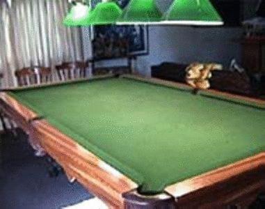 a green pool table in a room with a lamp at Ye Olde Station Guest House Birmingham, Shustoke in Shustoke