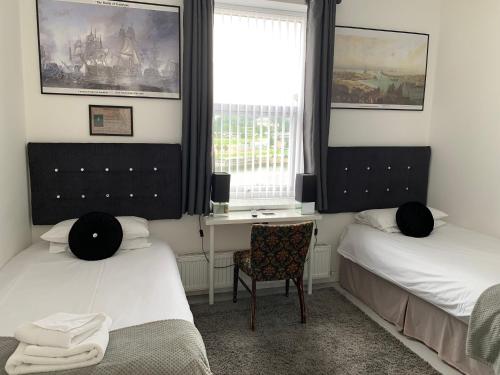 a bedroom with two beds and a desk and a chair at Boars Head Boutique Hotel in Sunderland