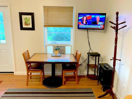 a dining room with a table and a tv on the wall at Micosta Leisure Inn in Hudson