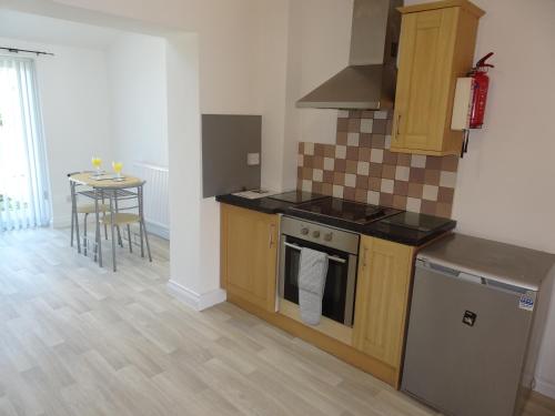 a kitchen with a stove and a table in it at St Margaret's House in Leamington Spa