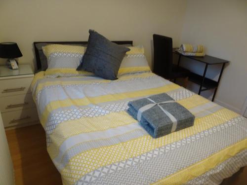 a bedroom with a bed with a yellow and blue blanket at St Margaret's House in Leamington Spa