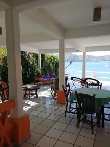a patio with a table and chairs and a view of the ocean at Bungalows pacíficos in Zihuatanejo