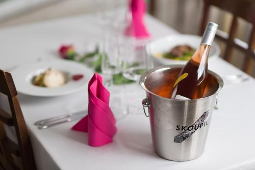 a bottle of wine in a bucket on a table at Rodinné Vinařství Skoupil in Velké Bílovice