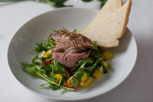 a plate of food with a salad and a sandwich at Rodinné Vinařství Skoupil in Velké Bílovice