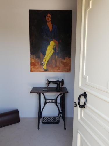 a painting of a woman sitting on a table next to a door at Εn Kanalion in Kanália