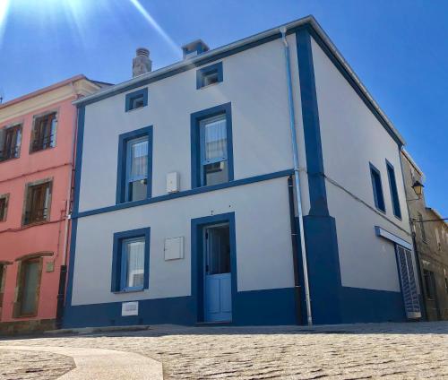 un edificio azul y blanco en una calle en Apartamentos Turísticos Casa Dina, en Rinlo