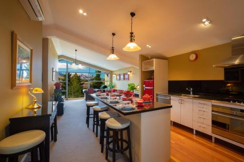 a kitchen with a long island with bar stools at Shotover Ridge in Queenstown