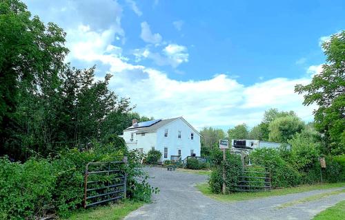 a white house with a fence next to a driveway at Micosta Leisure Inn in Hudson