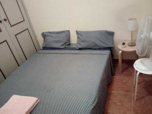 a bedroom with a bed with blue sheets and a table at Rooms 4 you - Small Yellow room in Portimão