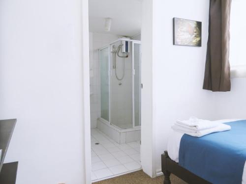 een badkamer met een douche en een bed in een kamer bij Bird Garden Guest House in Quito