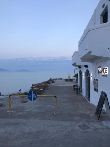 a building on the beach next to the water at Vrahos in Kardamaina