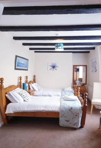 a bedroom with a bed and a black and white ceiling at Jolly Sailor Inn - THE OLDEST PUB IN LOOE - Family run and full of charm and character in Looe
