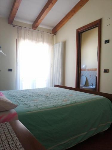 a bedroom with a green bed and a large mirror at casa bijoux in Itri