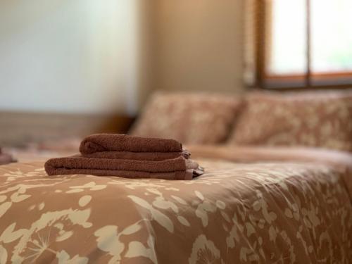 three towels are stacked on top of a bed at Maxim Apartment in Mavrovo