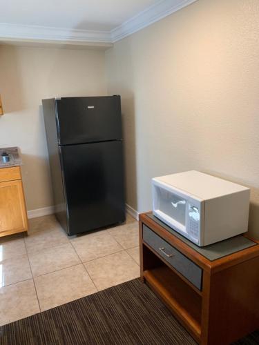 a kitchen with a black refrigerator and a microwave at A-1 Budget Motel in Klamath Falls
