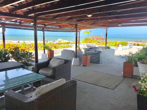a patio with chairs and a table and the beach at Penthouse Caribbean View and private pool, Cartagena in Cartagena de Indias