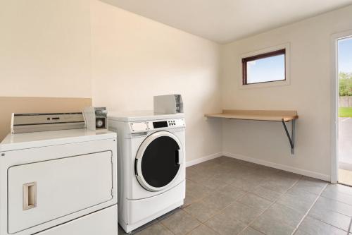 a laundry room with a washing machine and a window at Days Inn by Wyndham Middletown/Newport Area in Middletown