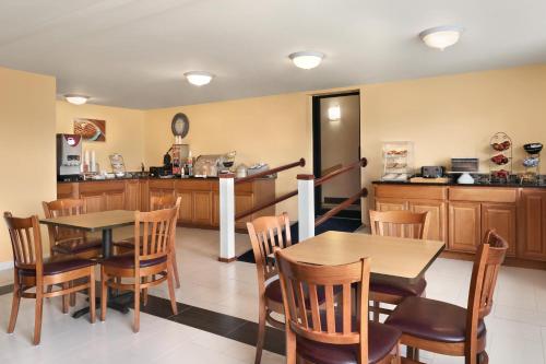 a kitchen and dining room with tables and chairs at Days Inn by Wyndham Middletown/Newport Area in Middletown