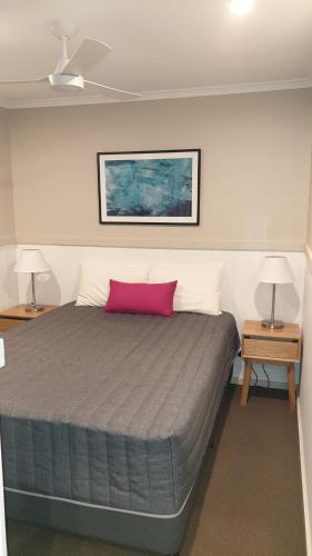 a bedroom with a large bed with a pink pillow at NRMA Victor Harbor Beachfront Holiday Park in Victor Harbor