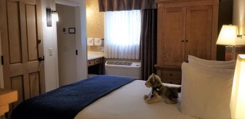 a teddy bear sitting on a bed in a hotel room at The Rockwell Inn in Jackson