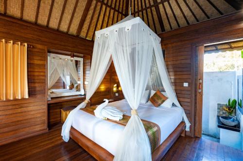 1 dormitorio con 1 cama con mosquitera en Smooth Garden, en Nusa Lembongan